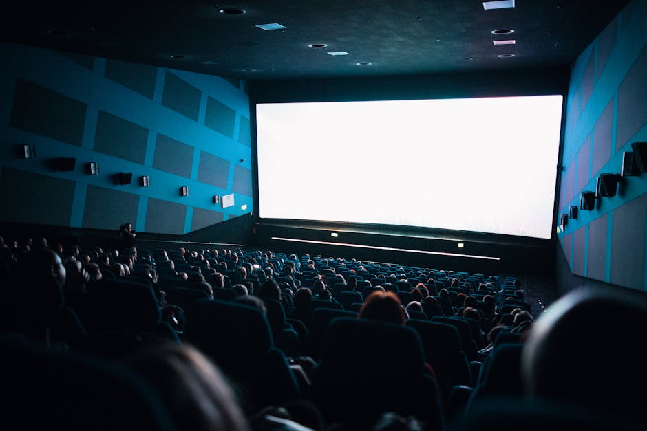 Crowded cinema audience watching a film on a large theater screen