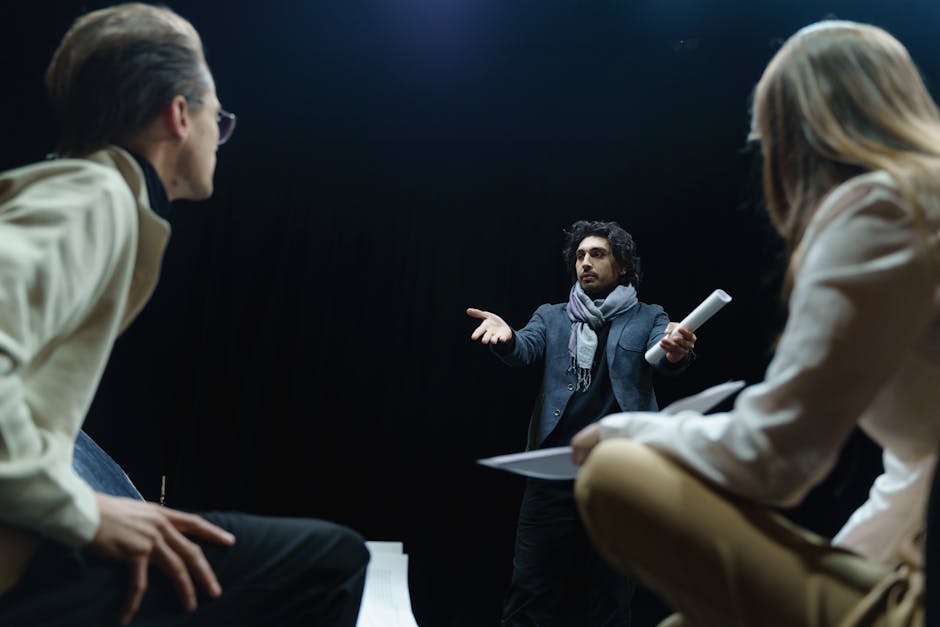 Actor performing a scene during a film audition, observed by two casting professionals in a dark studio space