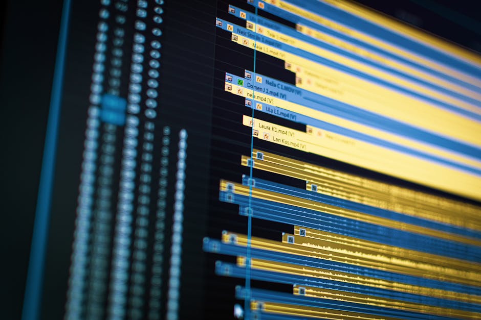 Close-up of a video editing timeline with multiple color-coded tracks on a dark monitor screen
