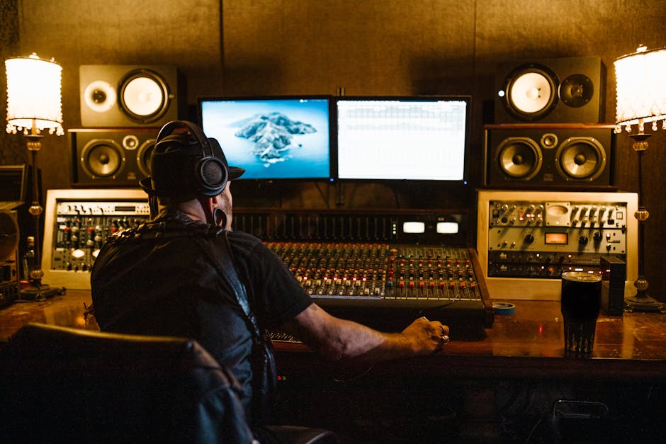 Music supervisor reviewing audio tracks at a professional mixing console with film footage on screens behind