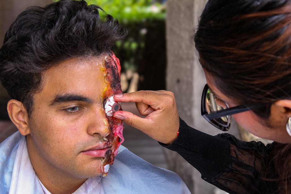 SFX makeup artist applying wound prosthetics to an actor's face during a film production shoot