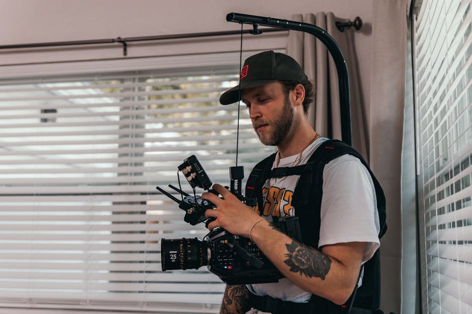 Cinematographer wearing a camera stabilizer harness and adjusting equipment indoors during a film shoot